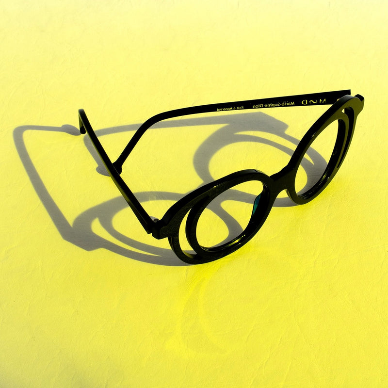 Monture légère noire signée Marie-Sophie Dion sur fond jaune — collection MSD Légère fabriquée à Montréal